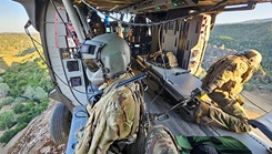 From left, U.S. Army Reserve Staff Sgt. Andrew Strohman, a combat medic specialist and U.S. Army Reserve Spc. Shavaun Brugger, a UH-60 helicopter repairer assigned to Charlie Company, 7th Battalion, 158th Aviation Regiment, peers out the door of a Black Hawk during a pinnacle landing amidst Mojave Falcon 2025