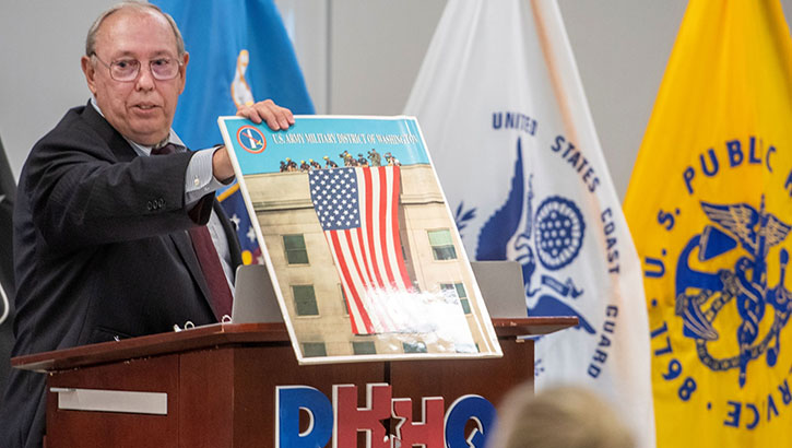 A man holds a picture of a flag.