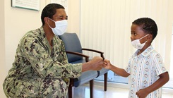 A man fist bumps a child.