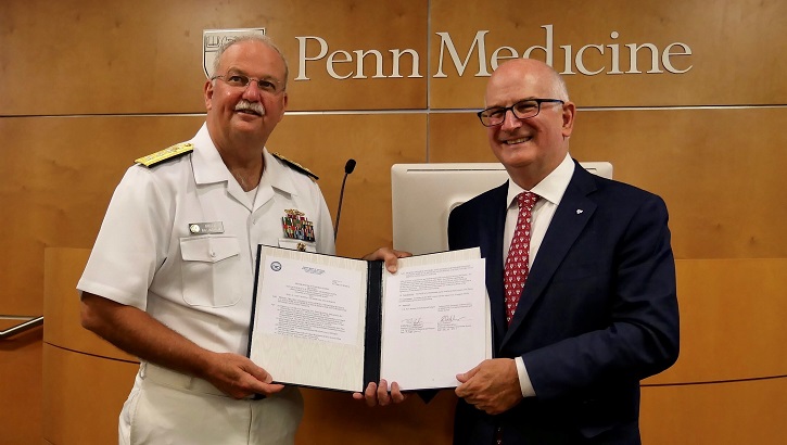 Navy Surgeon General RADM Bruce Gillingham and Kevin Mahoney, Chief Executive Officer for the University of Pennsylvania Health System, hold the signed agreement that starts a three-year partnership.