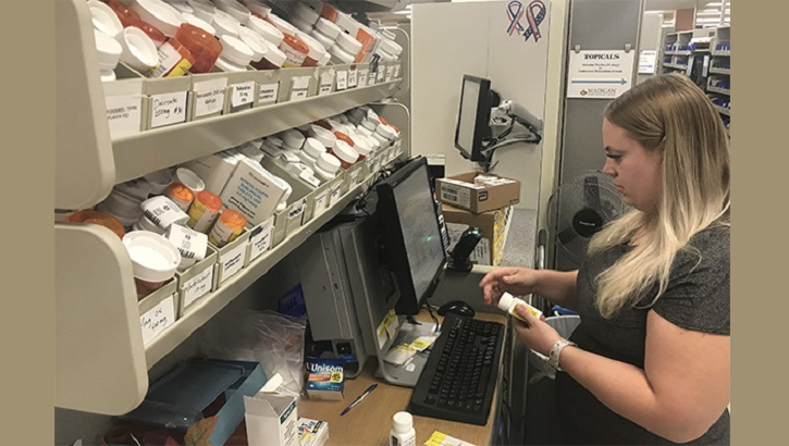 Pharmacist Ashley Burrill fills a prescription at the Madigan pharmacy on July 23. Assigning staff to their strongest roles helped to reduce the pharmacy wait time. (U.S. Army photo by Suzanne Ovel)