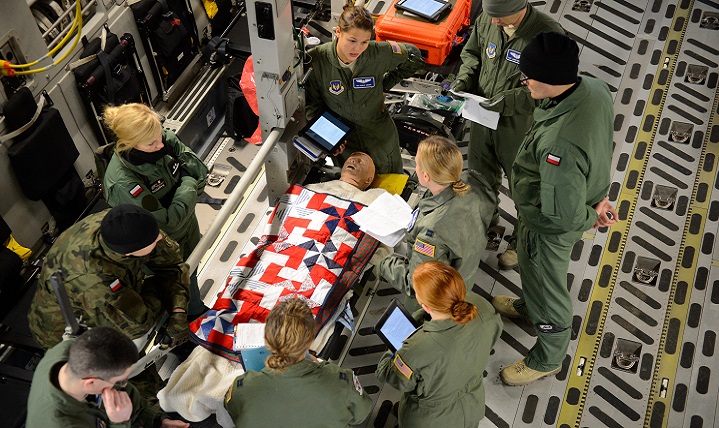Members from the 86th Aeromedical Evacuation Squadron and Polish aeromedical evacuation specialists discuss the proper treatment of a mock patient aboard a C-17 Globemaster III. Members of the 86th AES showcased their skills for the Polish medical officials in order for them to adapt desired skills. (U.S. Air Force photo by Staff Sgt. Armando A. Schwier-Morales)
