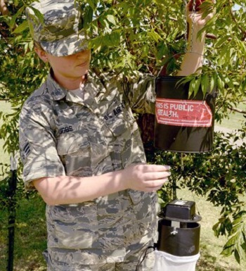 Military health personnel setting up a trap for mosquitos 