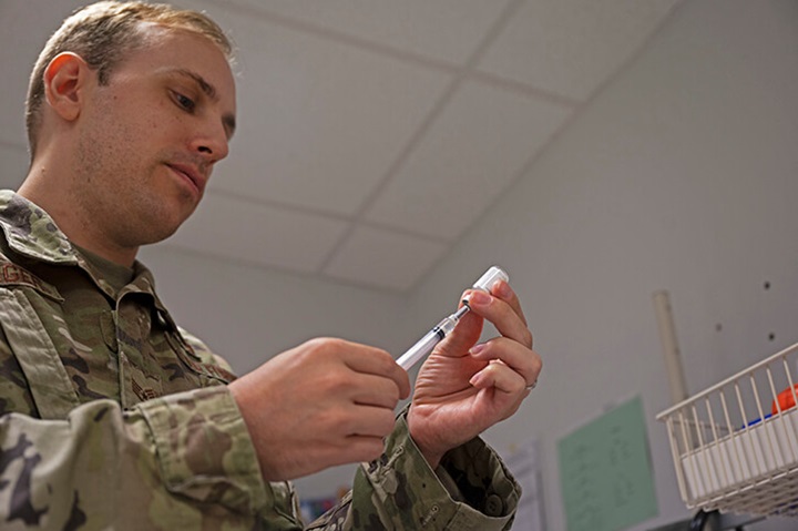 Image of Air Force Staff. Sgt. fills a syringe with a COVID-19 vaccine at Ramstein Air Base, Germany.