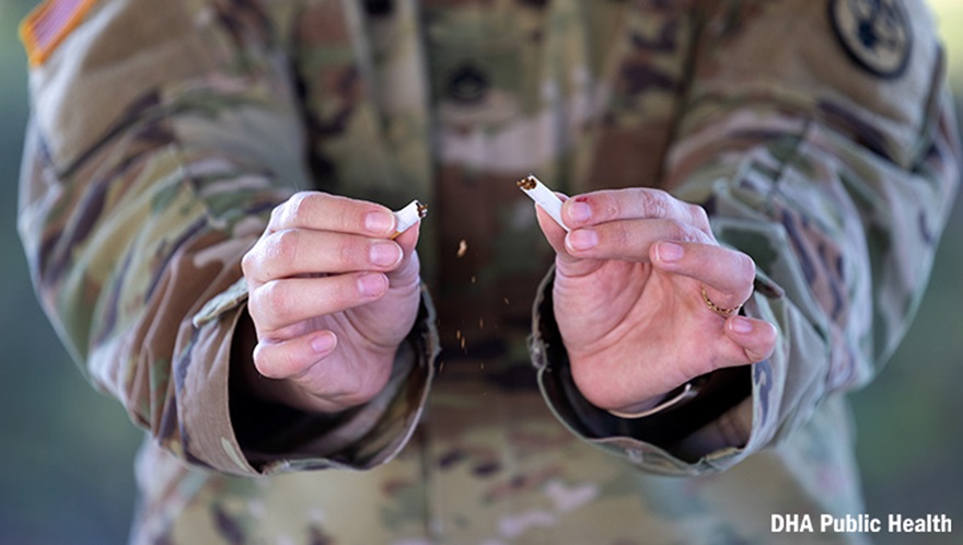 Military personnel breaking a cigarette in half