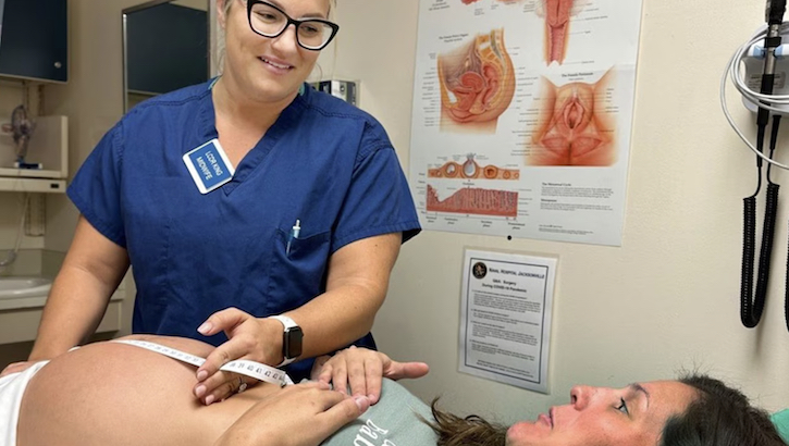 Navy Lt. Cmdr. Megan King, a certified nurse-midwife, uses a tape measure to determine fetal height on a maternity patient at Naval Hospital Jacksonville, Fla., Sept. 18, 2023.