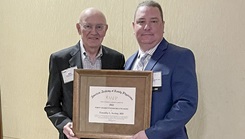 Two men pose with an award