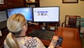 A woman looks at her computer monitor.