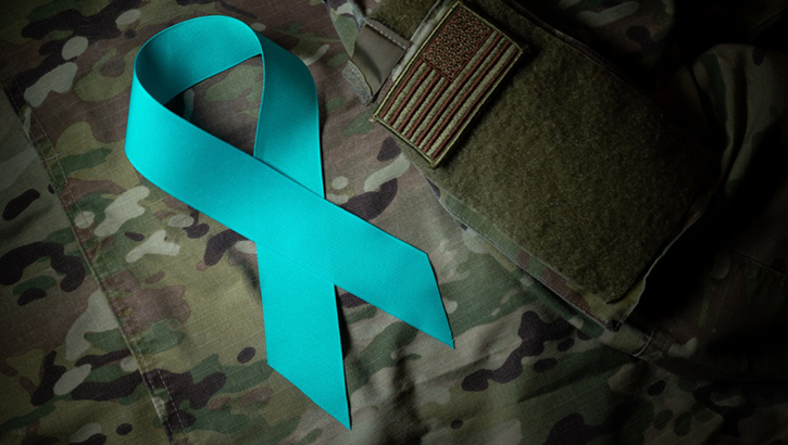 Image of teal ribbon against soldier's uniform.