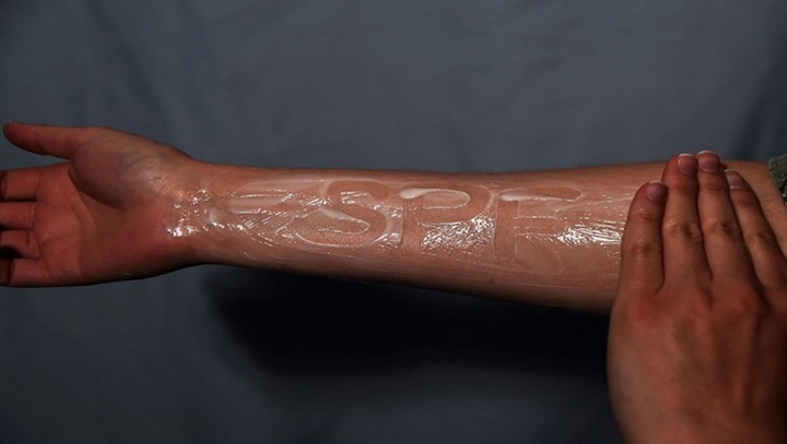 Image of SPF written in sunblock on someone's arm.