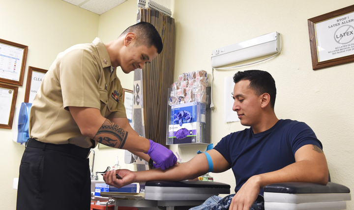 Navy Petty Officer 1st Class Oliver Arceo draws blood from a sailor at the Naval Air Station North Island medical clinic in Coronado, California, for routine HIV testing. (U.S. Navy photo by Petty Officer 1st Class Marie Montez)
