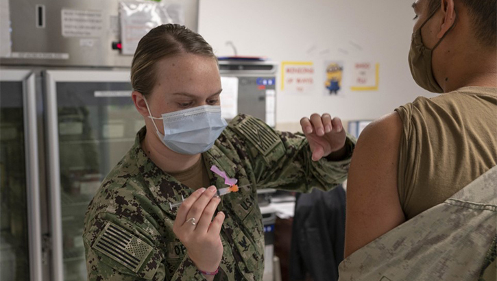 Image of Military personnel wearing a face mask receiving the COVID-19 vaccine. Click to open a larger version of the image.