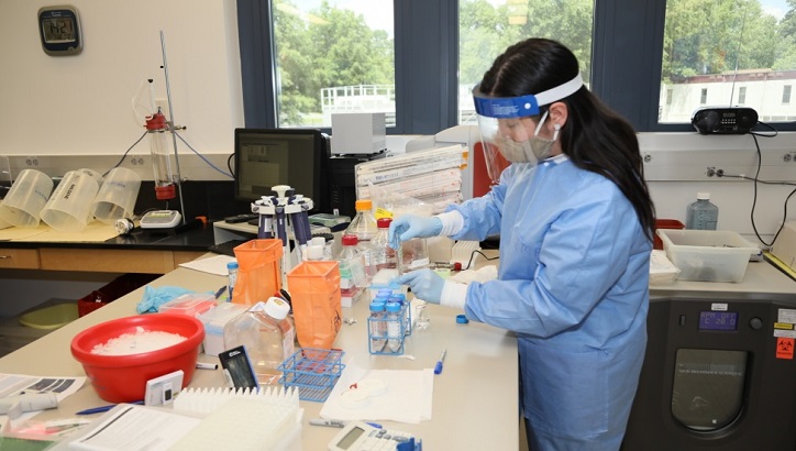 Image of Medical personnel in PPE, conducting lab tests.