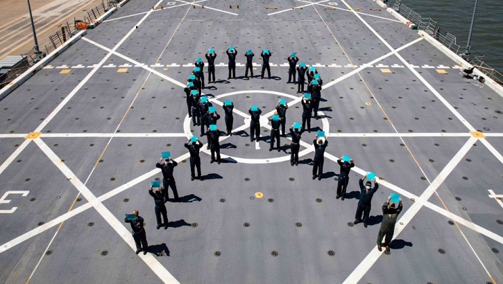 Military personnel for a teal ribbon on a flight deck