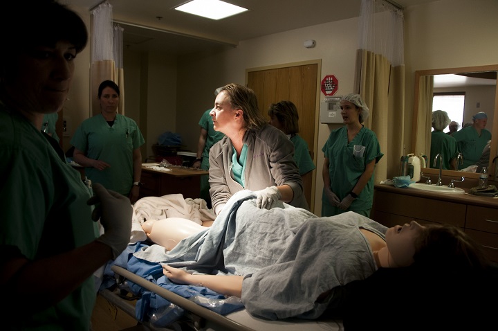 Regina Vadney, nurse midwife, William Beaumont Army Medical Center, evaluates a medical manikin using WBAMC's new simulation system which provides cutting-edge training to medical staff during a simulated postpartum hemorrhage scenario. The new simulation system aims to increase communication, and improve interdisciplinary and clinical performance of staff when treating obstetric emergencies. (U.S. Army photo by Marcy Sanchez)