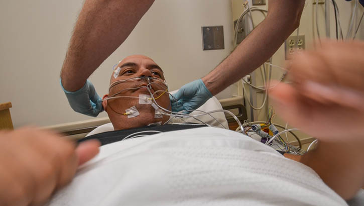 A service member participates in a sleep study at Madigan Army Medical Center, Joint Base Lewis-McChord in Washington.  Sleep technicians connect 26 sensors to patients that measure eye and muscle movements, brain activity, heart rate, and breathing.