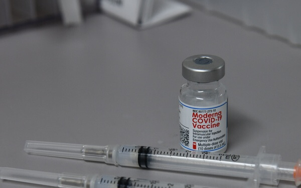 Image of COVID-19 vaccine bottle and syringes. Click to open a larger version of the image.