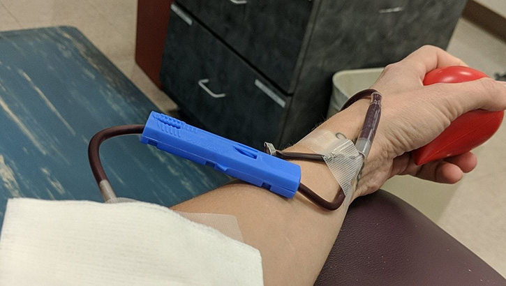 Image of Person's hand and arm, squeezing a ball, giving blood. Click to open a larger version of the image.