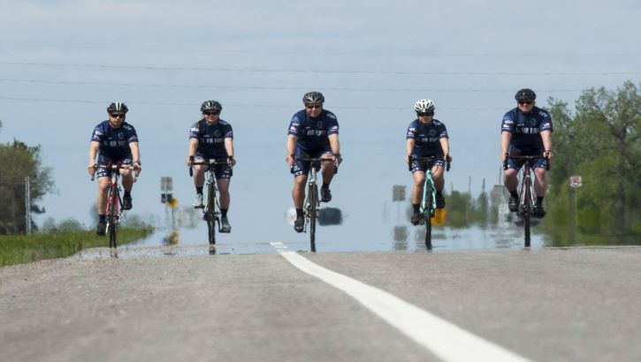 Image of Five Cyclists riding on the road.