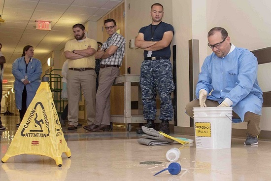 Mike Ende, Armed Forces Medical Examiner System forensic toxicology inventory manager, demonstrates proper techniques for cleaning up a spill to AFMES forensic toxicology personnel during Safe and Sound Week. Safe and Sound Week is a nationwide campaign to raise awareness and understanding of safety and health programs within the workplace. (U.S. Air Force photo by Staff Sgt. Nicole Leidholm)