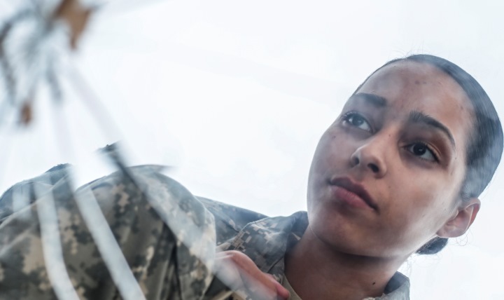 Army Private 1st Class Luselys Lugardo, a soldier assigned to the New Jersey Army National Guard, poses in front of a shattered mirror for a portrait. The shattered glass represents the way suicide hurts families, friends and coworkers. (U.S. Air Force photo by Tech. Sgt. Matt Hecht)