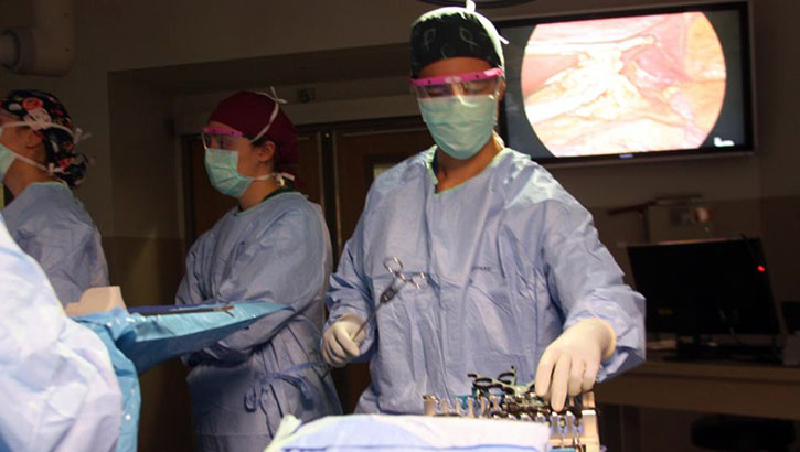 A surgical technologist at Walter Reed National Military Medical Center, assists a surgical team during a procedure in the operating room.