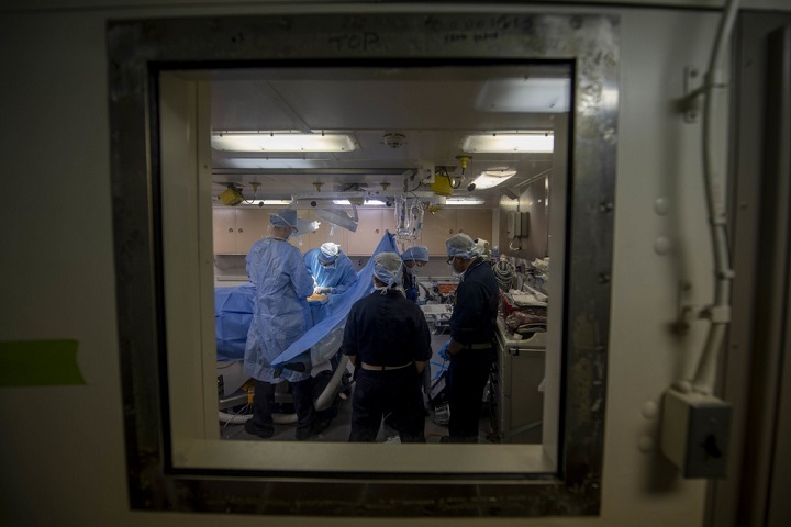 Navy Cmdr. Jeffrey Chao, the Littoral Combat Group One, surgeon, second from left, performs an emergency appendectomy as other medical team members assist aboard the San Antonio-class amphibious transport dock ship USS Somerset. (U.S. Navy Photo by Mass Communication Specialist 1st Class Andrew Brame)