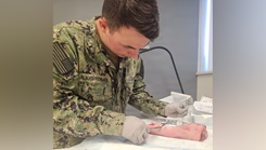 Hospitalman Apprentice Branden Slaughterback, from Navy Medicine Readiness and Training Command (NMRTC) Detachment Indian Head, practices wound closure techniques on a pig's foot 
