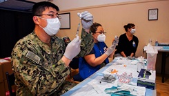 Two medical people prepare syringes with doses of the COVID-19 vaccine 