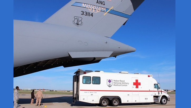 An ambulance bus backs up to the Mississippi Air National Guard C-17 Globemaster III as Airmen prepare to unload patients at Joint Base Andrews, Maryland. The bus transports the ill and/or injured to Walter Reed National Military Medical Center in Bethesda, Maryland. JBA and Travis Air Force Base, California, serve as the primary military entry points or hubs for patient distribution within the continental United States. (U.S. Air Force photo by Karina Luis)