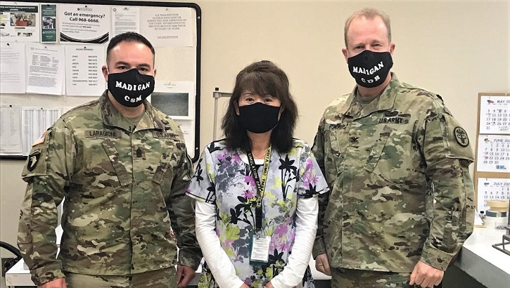 Three military personnel wearing masks