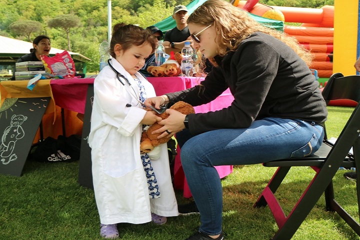 A corpsman teaches a child how stethoscopes work. During the Teddy Bear Health Clinic, children received a teddy bear, went from station to station making sure their new friend was healthy. The bears received patient identification bracelets, had their blood pressure taken, their hearts listened to, hearing tested, and even experienced an x-ray. The goal was to introduce children to different departments in the hospital and help alleviate any anxiety during future appointments or potential hospital stays. (U.S. Navy photo by Christina Clarke)