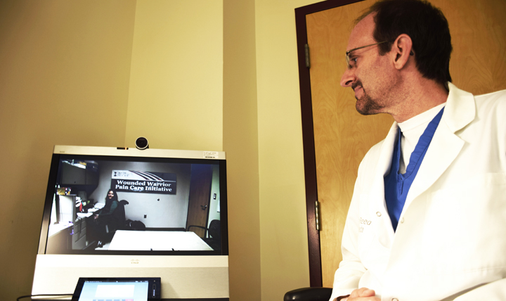 Dr. Christopher Spevak, director of the opioid safety program for the National Capital Region in and around Washington, D.C., uses the telehealth equipment at Walter Reed National Military Medical Center, Bethesda, Maryland. (DoD photo by Kalila Fleming) 