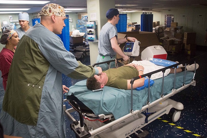 Navy Lt. Cmdr. Arthur Lammers, an anesthesiologist assigned to the hospital ship USNS Comfort, practices patient transfer during a mass casualty exercise. (U.S. Army photo by Spc. Joseph DeLuco)