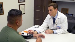 A doctor looks at a patient's prosthetic arm.