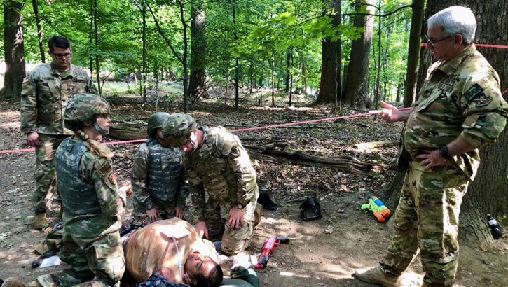 An instructor gives advice on how a team of medical school students at the Uniformed Services University should work on their simulated patient during the Advanced Combat Medical Experience. 