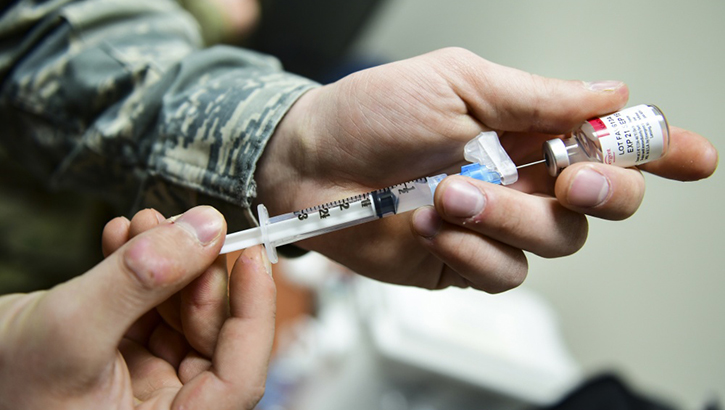 Image of Soldier filling a vaccine needle. Click to open a larger version of the image.