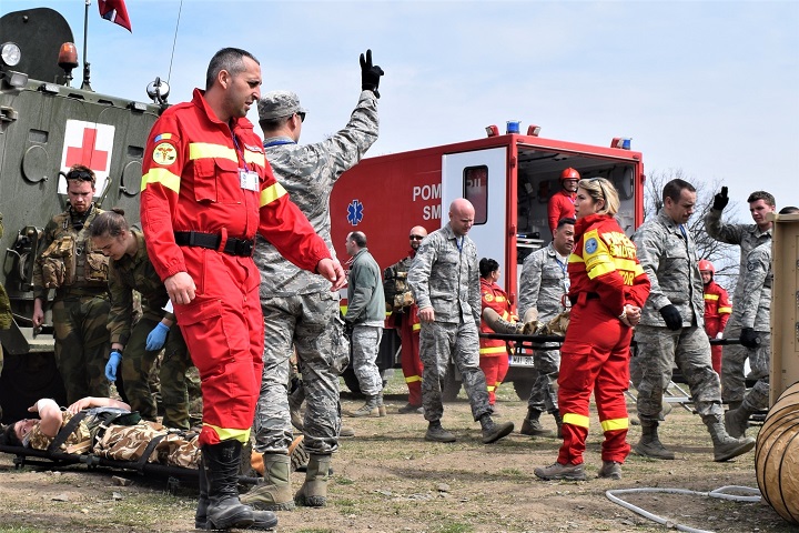 Civilian first responders from Romania participate along with Airmen from the 86th Medical Group, Ramstein Air Base, Germany, in a multinational medical exercise drill during Vigorous Warrior 19, Cincu Military Base, Romania. Vigorous Warrior 19 is NATO’s largest military medical exercise, uniting more than 2,500 participants from 39 countries to exercise experimental doctrinal concepts and test their medical assets together in a dynamic, multinational environment. (U.S. Air Force photo by 1st Lt. Andrew Layton)