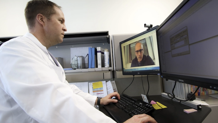 Image of U.S. Air Force Lt. Col. Brendt Feldt, a surgeon at Landstuhl Regional Medical Center’s Ear, Nose and Throat Clinic, conducts a virtual health appointment via synchronous video, April 7, 2020. In a session at the Defense Health Information Technology Symposium, key experts in health care IT discussed how leveraging technology, such as MHS Video Connect, can better connect patients and providers. (Photo: Marcy Sanchez).