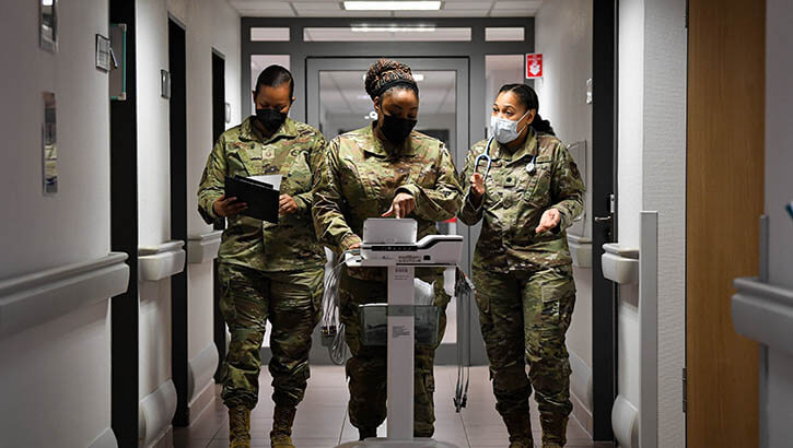 Military personnel looking at a patient's cardiac rhythm