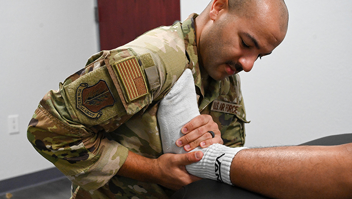 U.S. Air Force Capt. Chase Leavy, 97th Operation Support Team physical therapist, works on the ankle of U.S. Air Force Senior Airman Geraldo Fernandez Colon, 97th Security Forces Squadron visitor center clerk, at Altus Air Force Base, Oklahoma, Aug. 16, 2024. The purpose of the exercise is to increase mobility.