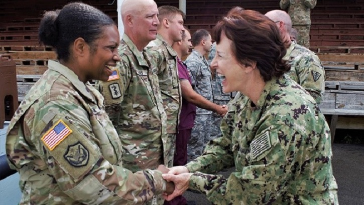 Navy Rear Adm. Mary Riggs greets Army Maj. Angela Hinkson