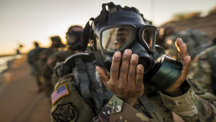 Image of Military personnel putting on a gas mask.