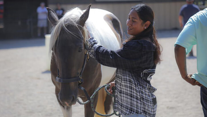Image of Horse on left with ARNG Spc. Yesenia Flores, at an equine therapy program used by Fort Campbell's Soldier Recovery Unit.