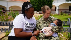 Brianna Abney, left, watches as Navy Lt. Kathleen Carter holds baby Keilah during a reunion at U.S. Naval Hospital Rota