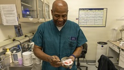 Anaplastologist Louis Gilbert touches up a dental prosthetic at the Maxillofacial Lab