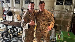 U.S. Air Force Lt. Col. Geoff Garst and Maj. Ed Fenton complete a training handoff providing en route care on a MC-130 aircraft as part of a Special Operations Force Medical Element team supporting the Air Force Special Operations Command in Southwest Asia