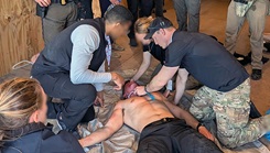 Physicians, medics, and agents work a simulated casualty together during the culminating mass casualty exercise