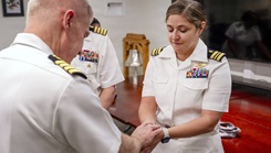 U.S. Navy Lt. Cmdr. Alainna Crotty, a native of Harrisburg, Pennsylvania, has her hands blessed by Capt. William Hlavin, the Navy Medicine Enterprise chaplain