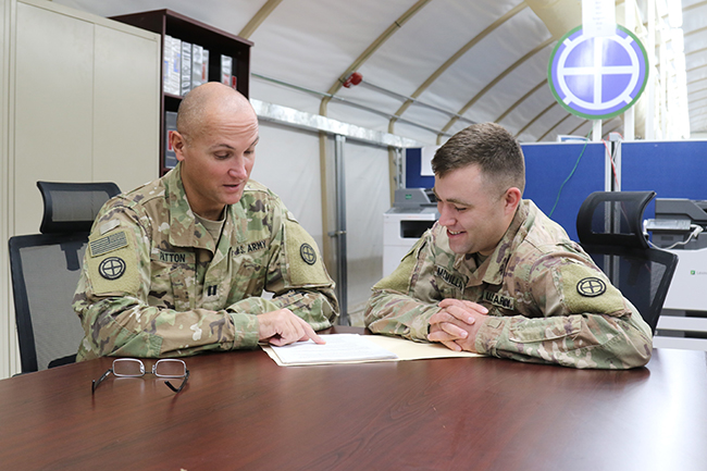 Army Staff Sgt. Michael McMillan (right), 35th Infantry Division behavioral health noncommissioned officer in charge, confers with Army Capt. Trever Patton, 35th ID psychologist, in Kuwait. Embedded behavioral health teams are a key part of providing easy access to care for service members. (Army photo by Staff Sgt. Tina Villalobos)